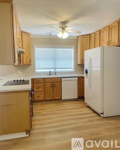 A kitchen with wooden cabinets and a white refrigerator.