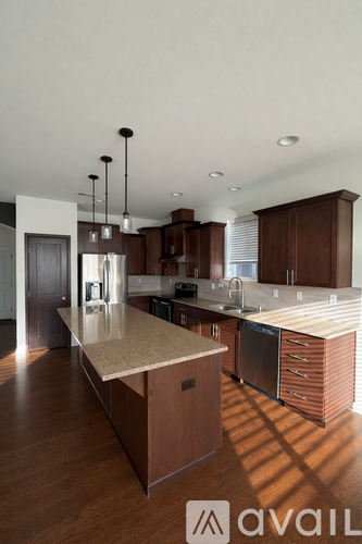 A modern kitchen with wooden cabinets and a marble countertop.