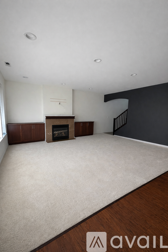 A living room with a fireplace and a carpet.