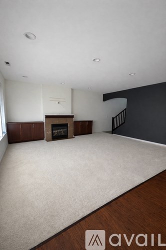 A living room with a fireplace and a carpet.