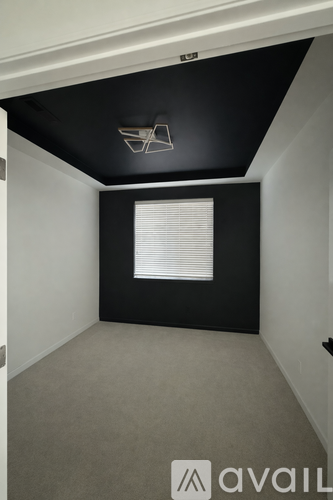 A room with a black ceiling and a window with blinds.