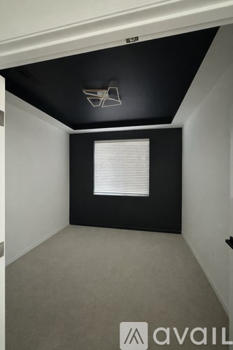 A room with a black ceiling and a window with blinds.