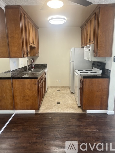 A kitchen with wooden cabinets and a white refrigerator.