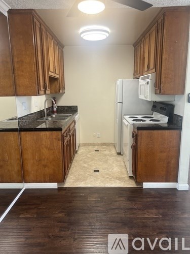 A kitchen with wooden cabinets and a white refrigerator.