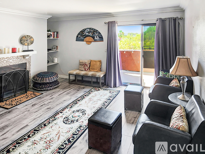 A living room with a fireplace, a sofa, a coffee table, and a rug.