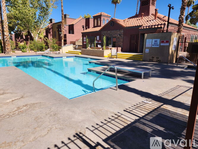A pool surrounded by a fence and a building in the background.