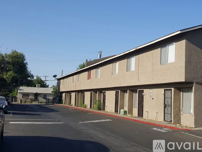 A street view of apartment buildings with a car parked on the side.