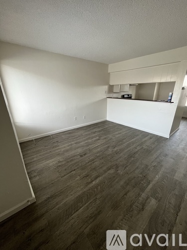 A room with wooden flooring and white walls.