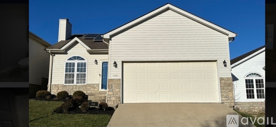 A house with a garage door and a window is for sale.