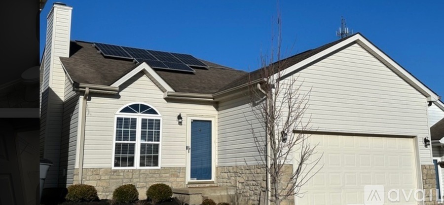 A house with solar panels on the roof and a garage door.