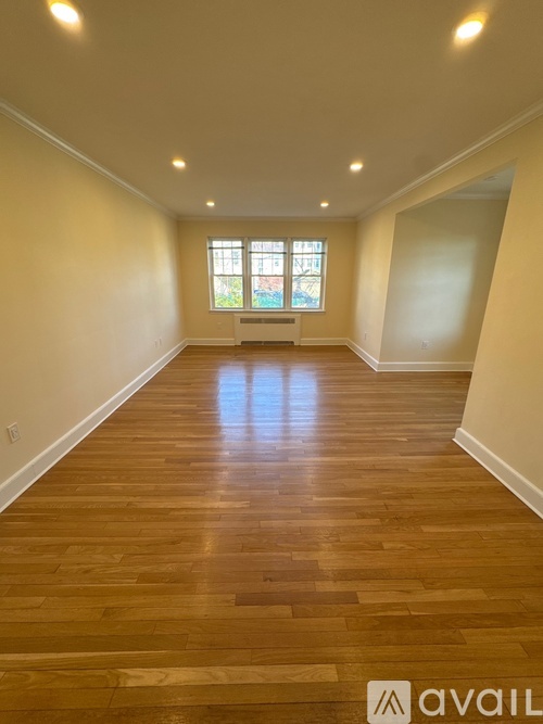 A room with wooden flooring and a window.
