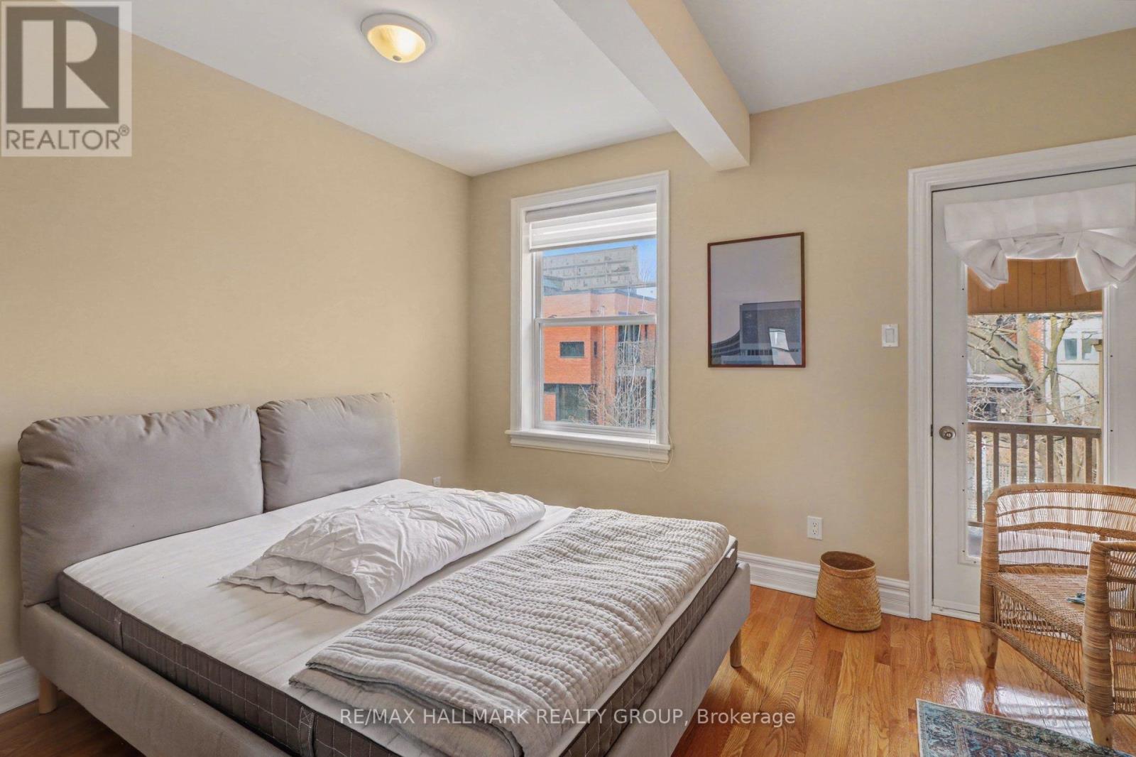 A bedroom with a large bed and a window overlooking a cityscape.
