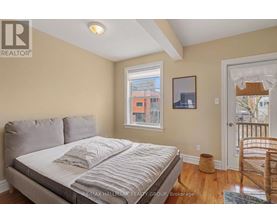 A bedroom with a large bed and a window overlooking a cityscape.