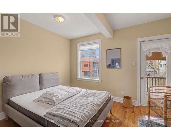 A bedroom with a large bed and a window overlooking a cityscape.