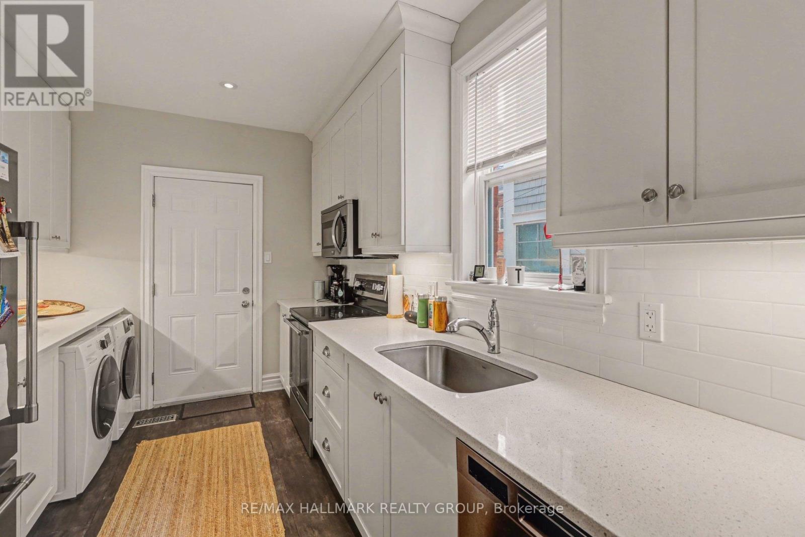 A kitchen with white cabinets and a white door.