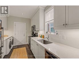 A kitchen with white cabinets and a white door.