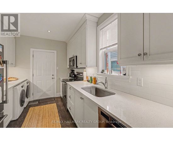 A kitchen with white cabinets and a white door.