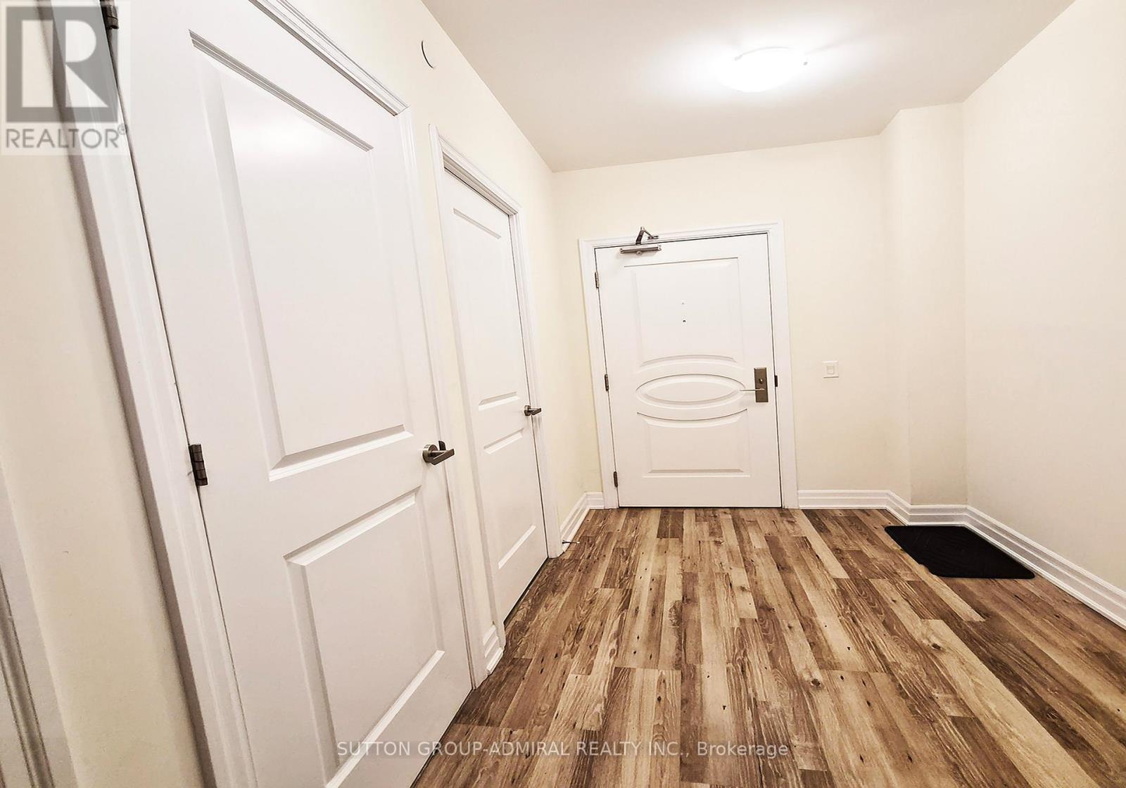 A hallway with white doors and a wooden floor.
