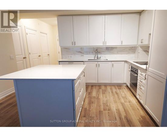 A kitchen with white cabinets and a blue island.