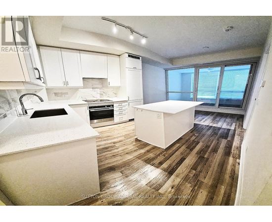 A kitchen with white appliances and wooden floors.