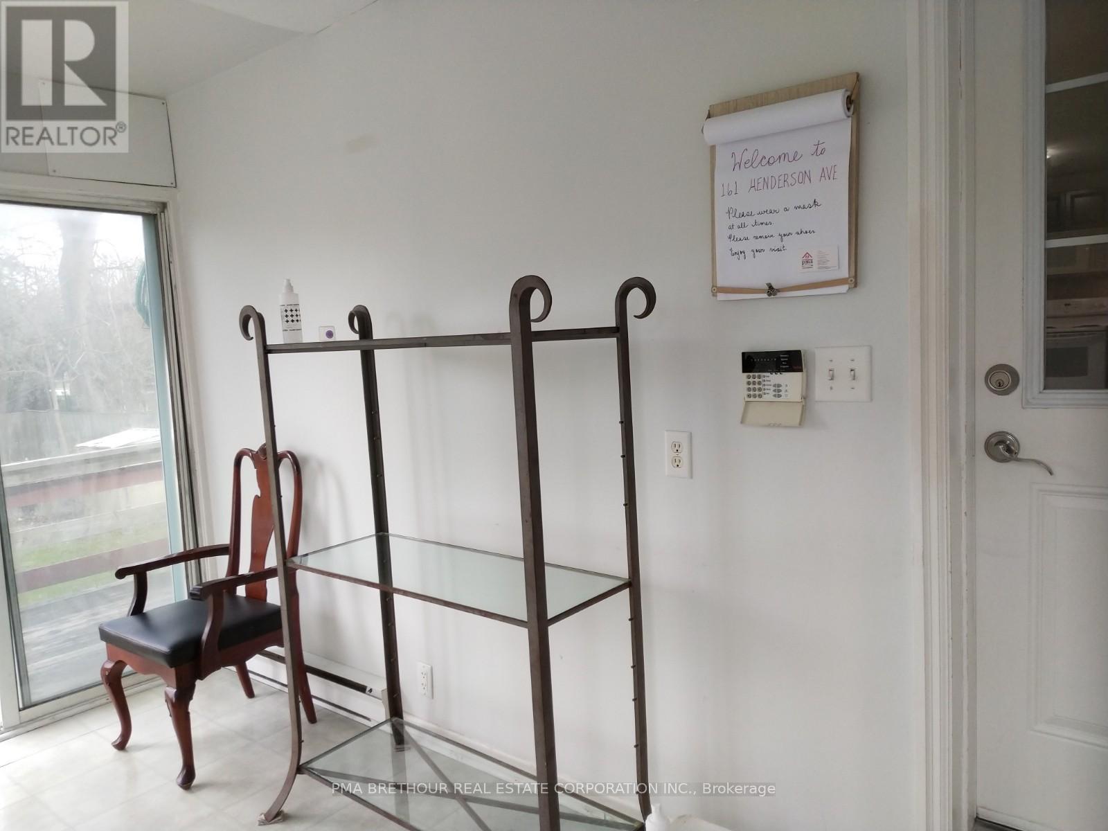 A room with a four-poster bed and a chair.