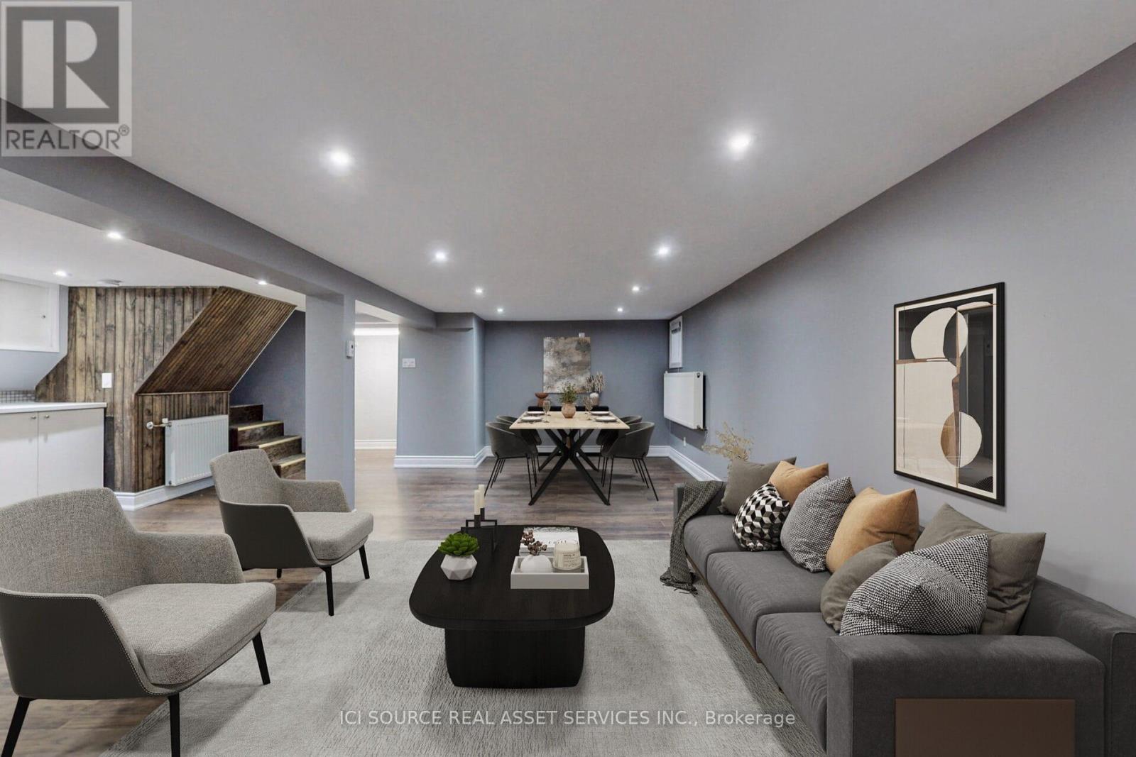 A modern living room with a grey sofa, a coffee table, and a dining table with chairs.