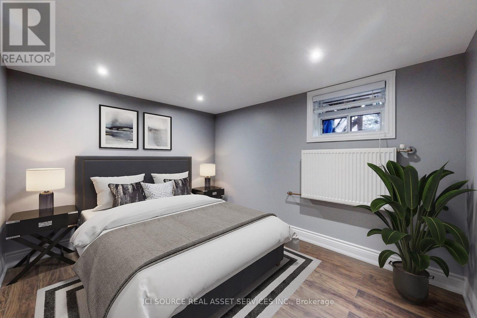 A bedroom with a large bed and a potted plant.