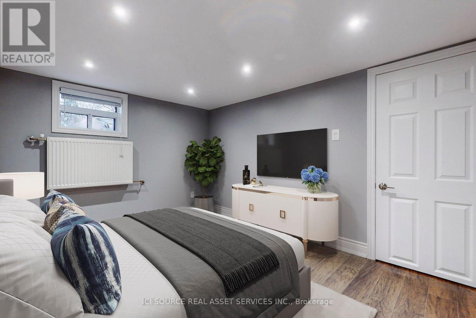 A bedroom with a bed, a dresser, and a window.