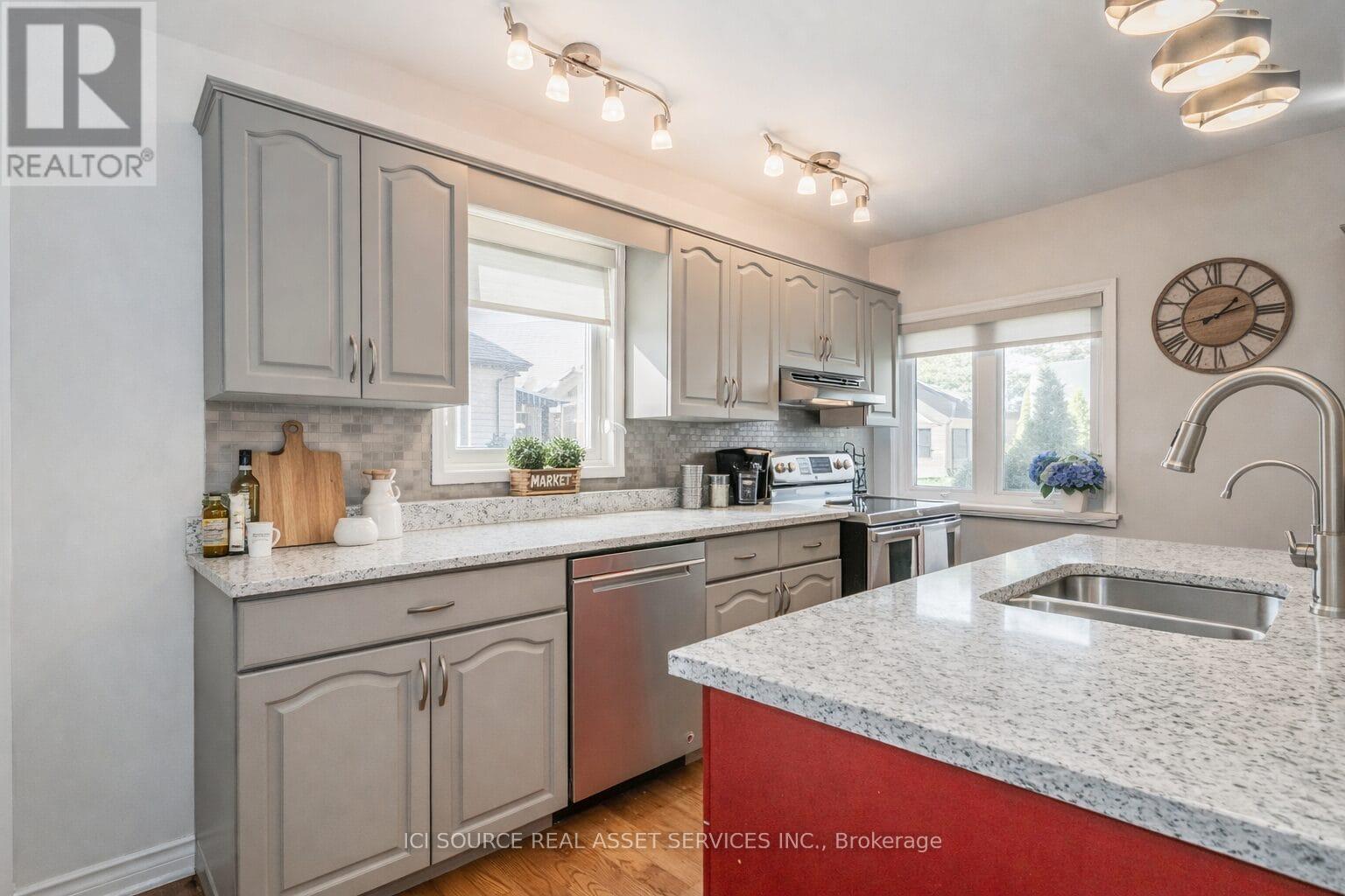 A kitchen with a red countertop and grey cabinets.