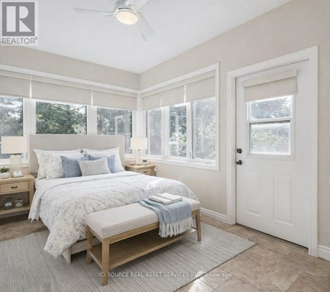 A bedroom with a large bed and a window with blinds.