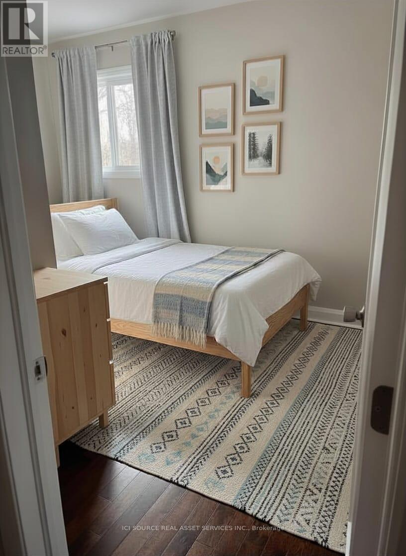 A bedroom with a bed, a rug, and pictures on the wall.