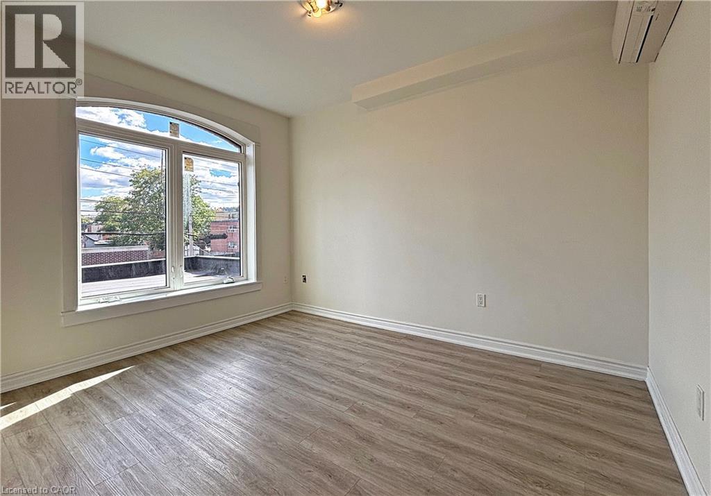 A room with a large window and wooden flooring.