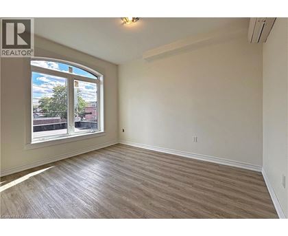 A room with a large window and wooden flooring.