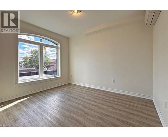 A room with a large window and wooden flooring.