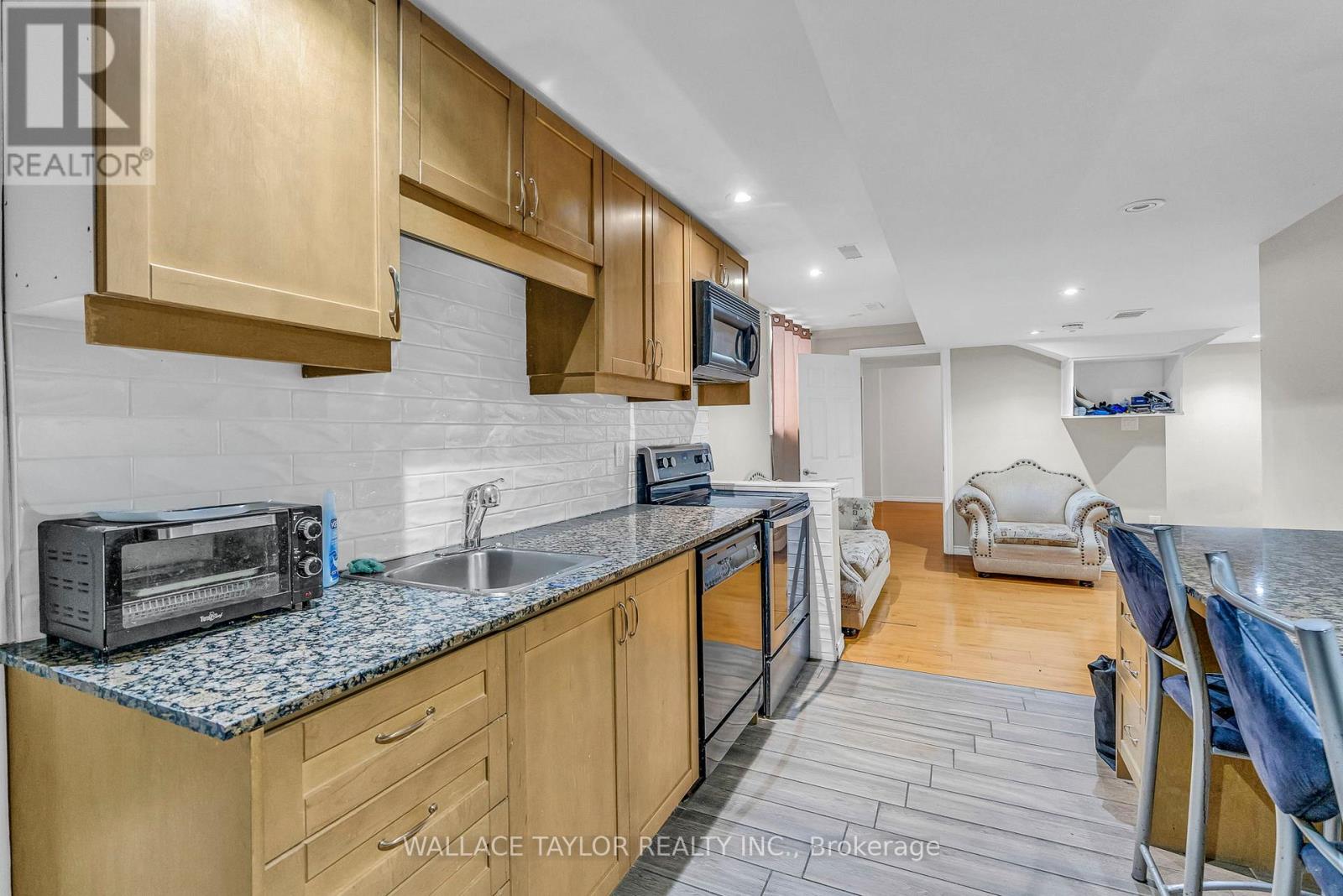 A kitchen with wooden cabinets and a black toaster oven on the counter.