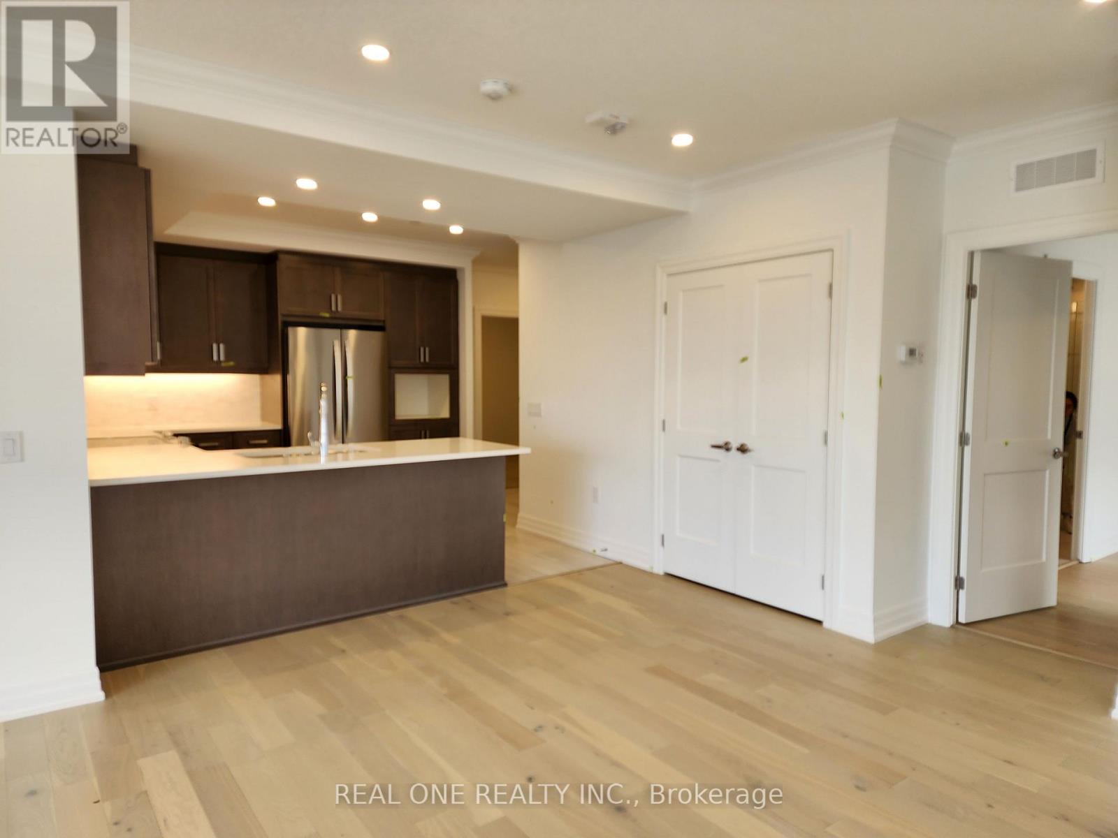 A modern kitchen with wooden floors and white walls.