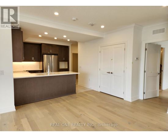 A modern kitchen with wooden floors and white walls.