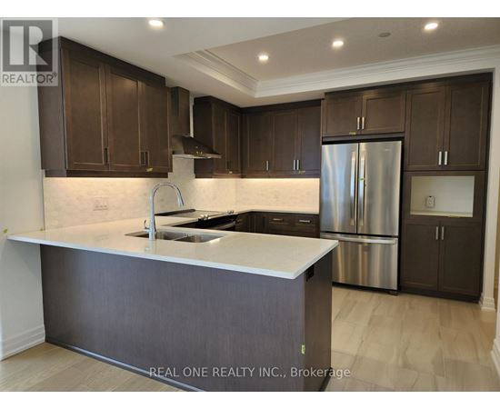 A modern kitchen with dark brown cabinets and a stainless steel refrigerator.