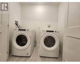 Two front load washing machines in a laundry room.