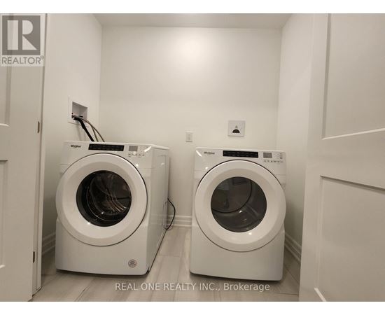 Two front load washing machines in a laundry room.