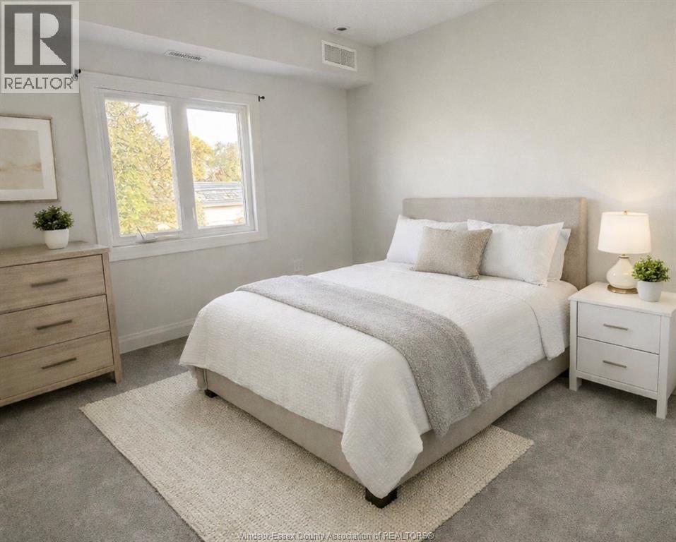 A bedroom with a large bed, a nightstand, and a dresser.