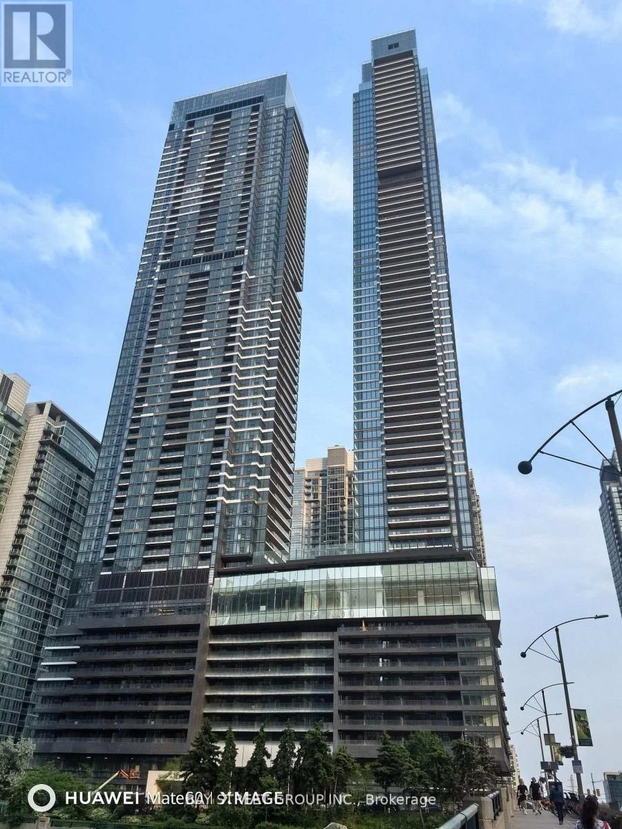 Two tall buildings with glass windows and balconies are shown in the image.