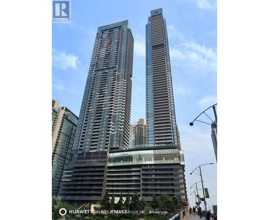 Two tall buildings with glass windows and balconies are shown in the image.