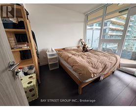 A bedroom with a bed, a window, and a cat on the bed.