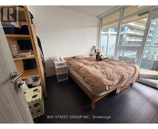 A bedroom with a bed, a window, and a cat on the bed.