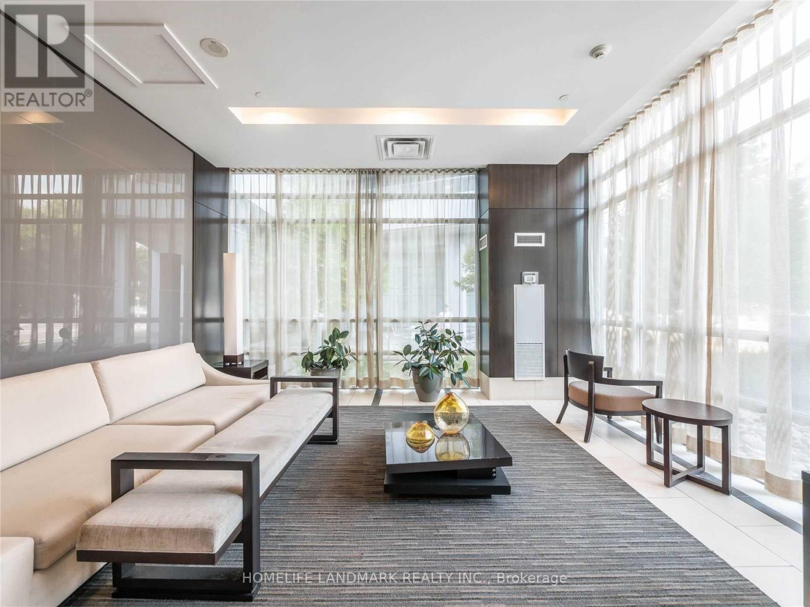 A modern living room with a large window and a wooden coffee table.