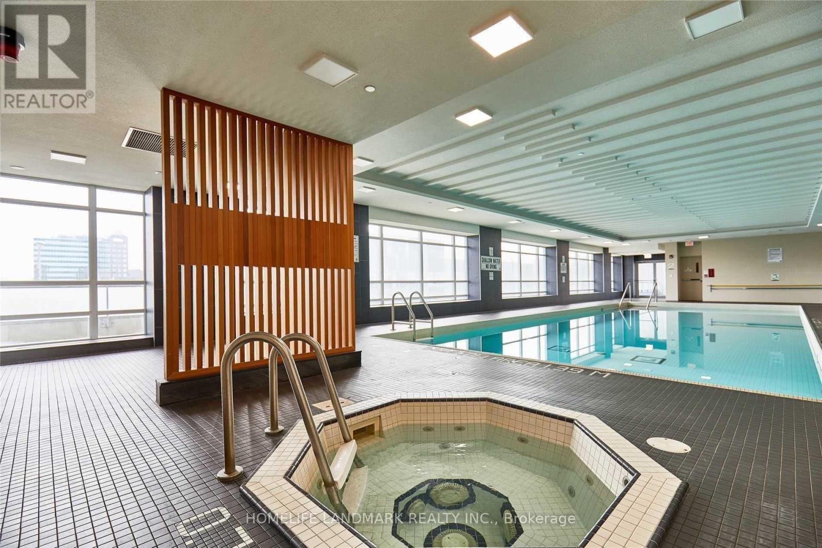 A large indoor swimming pool with a hot tub in the middle.