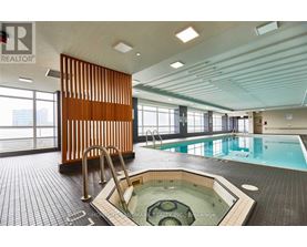 A large indoor swimming pool with a hot tub in the middle.