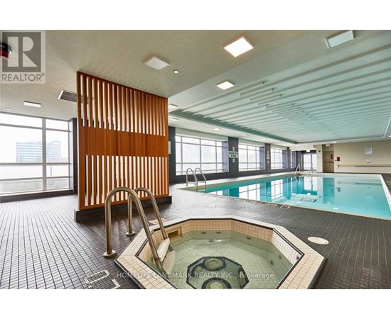 A large indoor swimming pool with a hot tub in the middle.