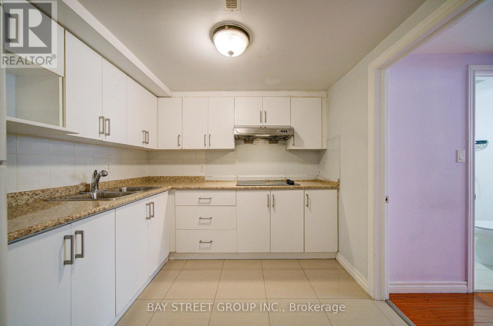 A kitchen with white cabinets and a granite countertop.